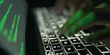 a hand typing on a lit up keyboard hero image